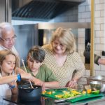 Multi-generational family enjoying cooking together in a modern kitchen setting.